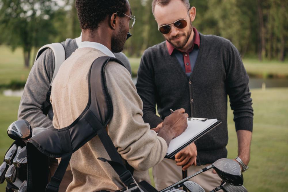 Group of people discussing a golf tournament with custom logo golf balls