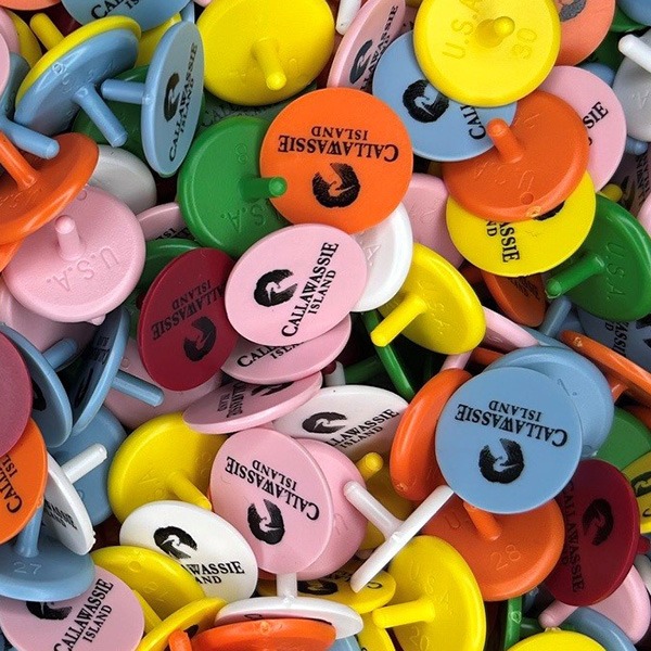 Custom golf ball markers in assorted bright colors with printed logos