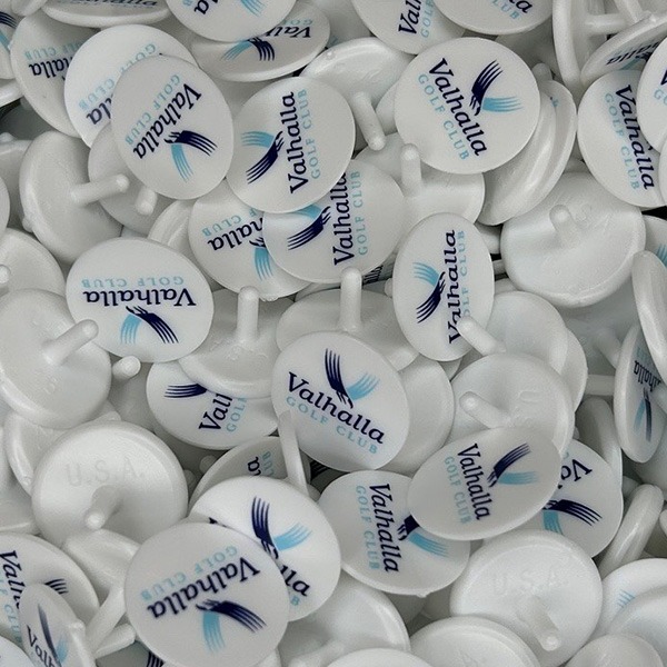 White branded golf ball markers printed with a blue company logo