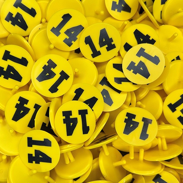 Yellow custom golf ball markers printed with bold black numbers