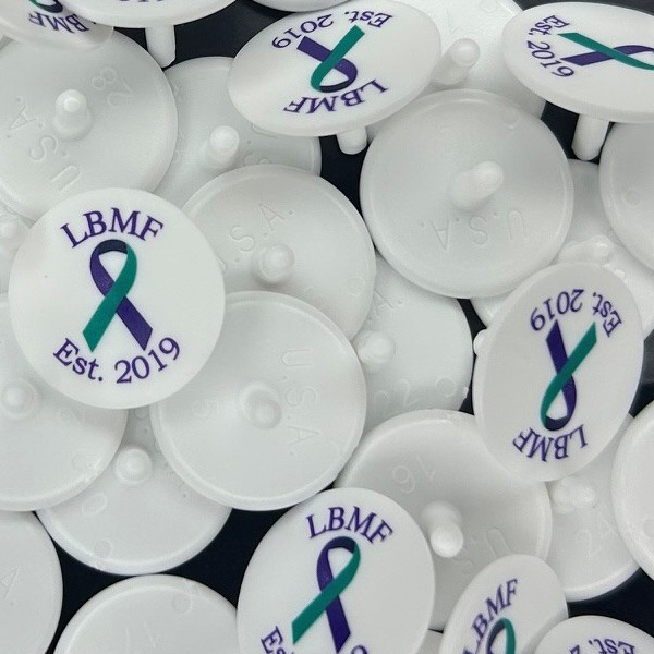 White personalized golf markers with an awareness ribbon logo