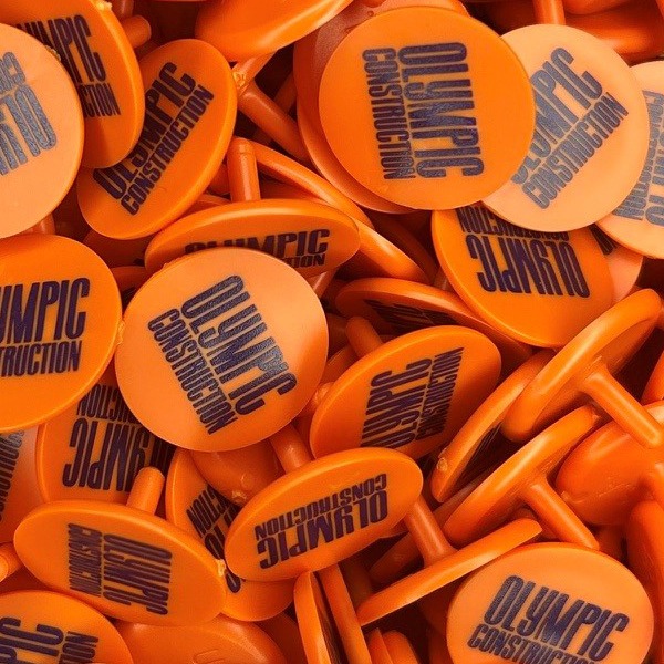 Orange personalized golf markers printed with a black company logo