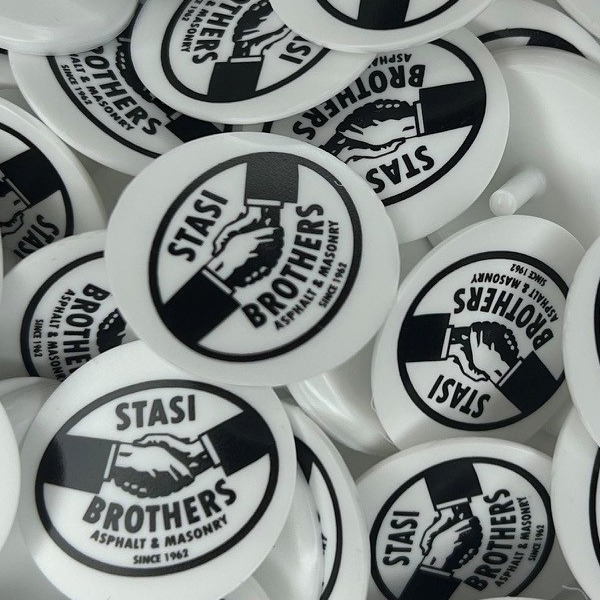 White bulk golf markers printed with a black handshake logo