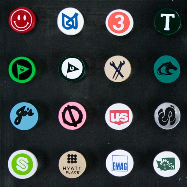 Custom golf tees featuring assorted business and event logos on the tee cups