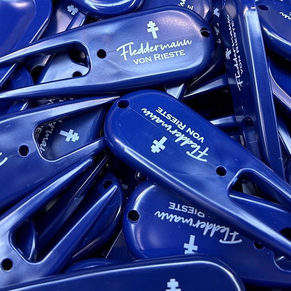 Blue custom divot tools printed with assorted white logo designs