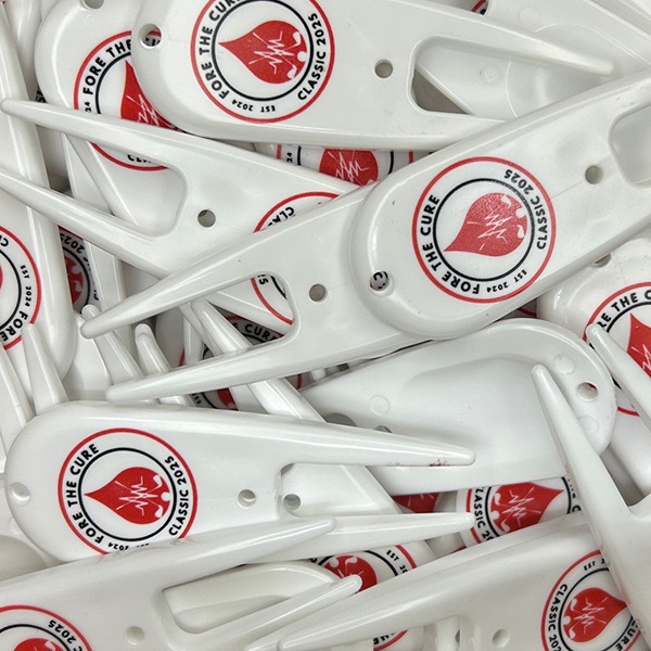 White custom divot repair tools featuring red circular logo designs