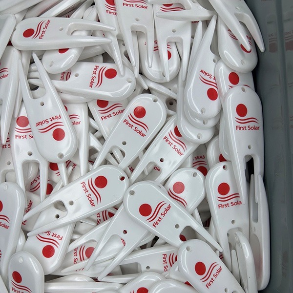 White custom divot repair tools printed with red company logos