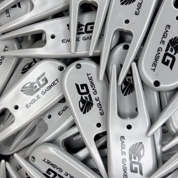 Silver custom divot repair tools printed with black company logos