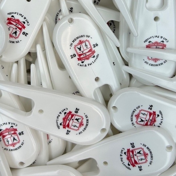 White personalized divot repair tools printed with a memorial celebration logo