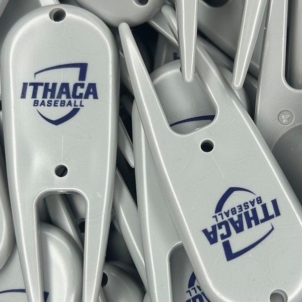 White custom divot tools printed with a navy baseball logo