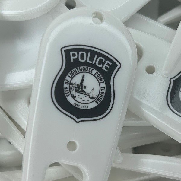 White personalized divot tools printed with a police department badge