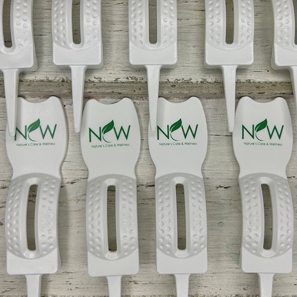 White divot tools printed with a green company logo