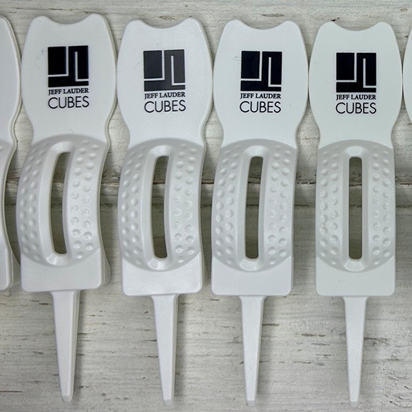 White custom divot repair tools printed with a black company logo