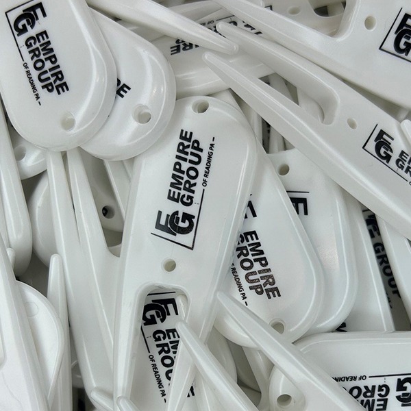 White divot tools printed with a black company logo