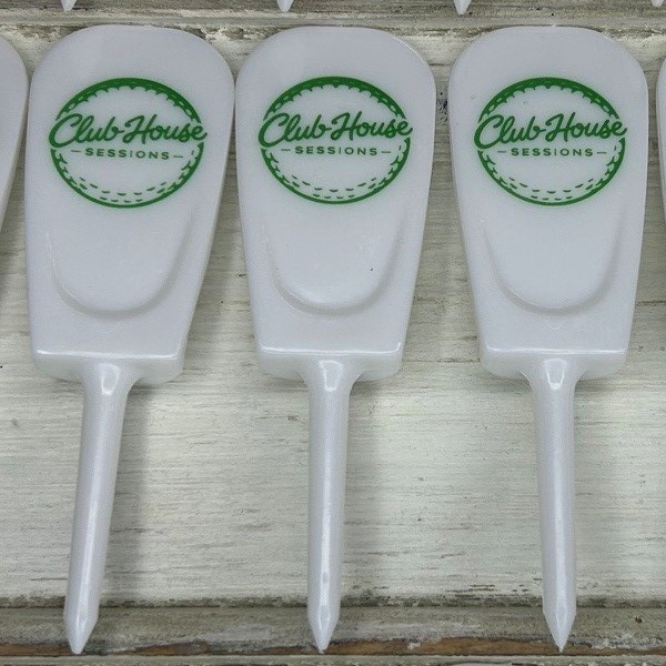 White divot tools printed with a green circular logo