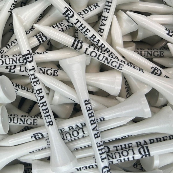 White personalized golf tees printed with a black barbershop logo