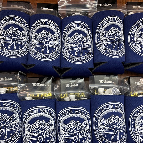Blue custom can koozies packed in golf tournament gift bags