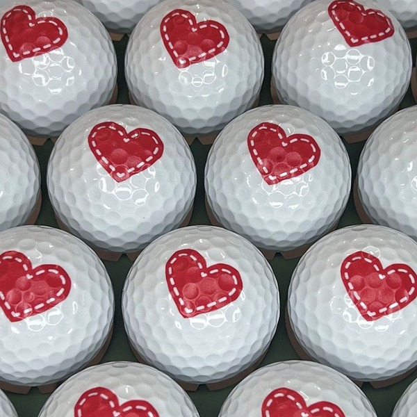 Custom golf balls printed with a red heart design
