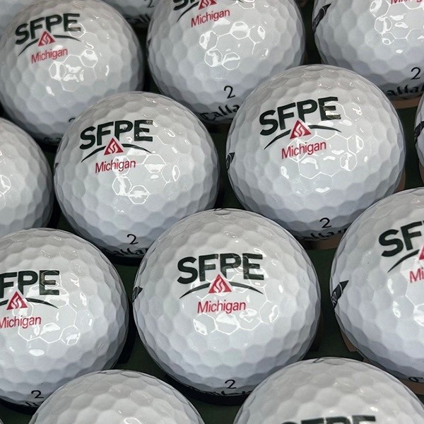 Custom logo golf balls featuring black and red organization branding