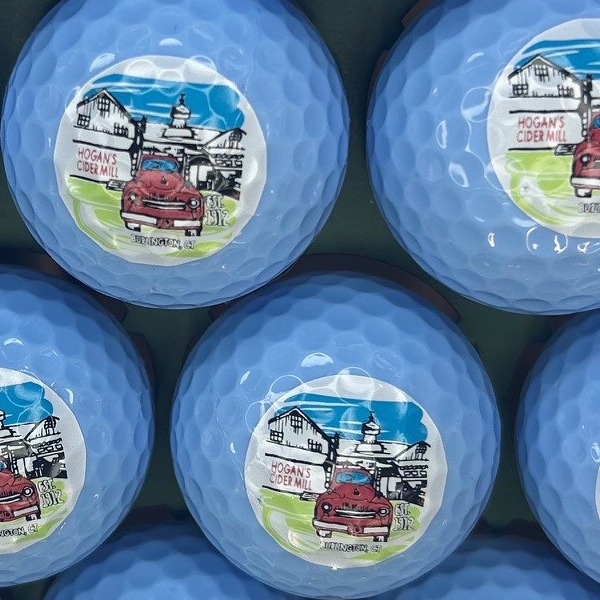 Light blue personalized golf balls featuring a full-color illustrated design