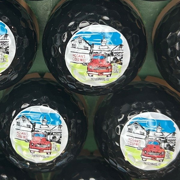 Black custom golf balls printed with a full-color illustrated design