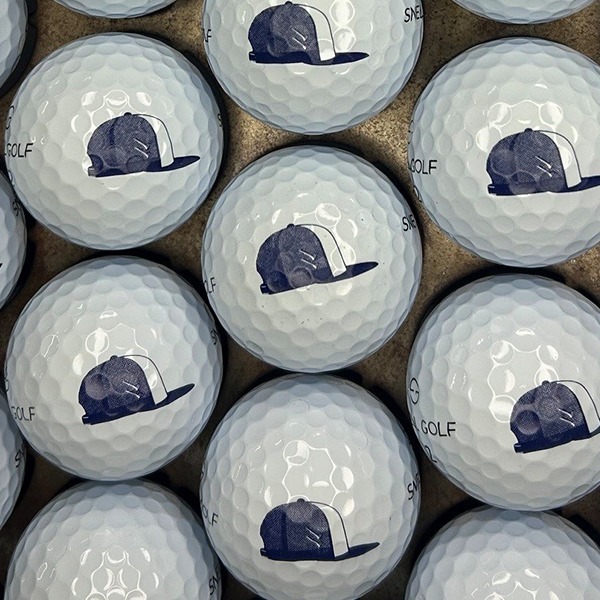 White logo golf balls printed with a navy baseball cap design