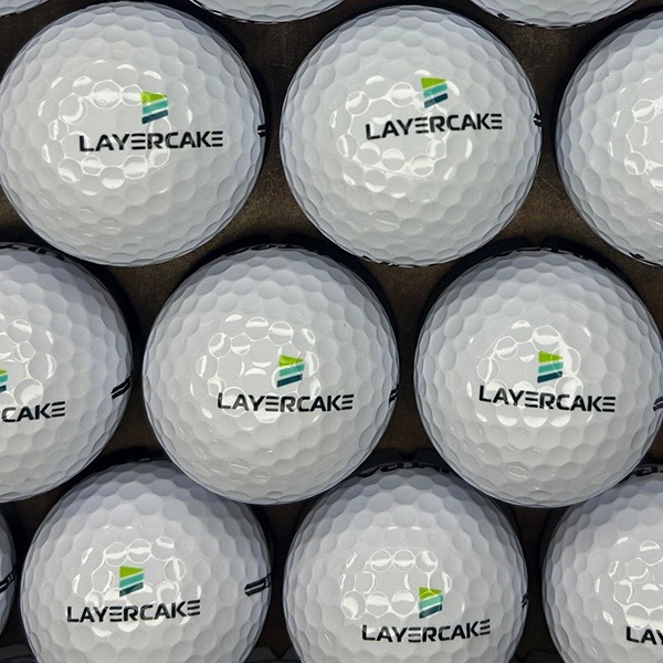 White branded golf balls printed with a black and green company logo
