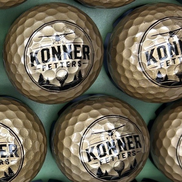 Gold custom golf balls printed with a black and white logo