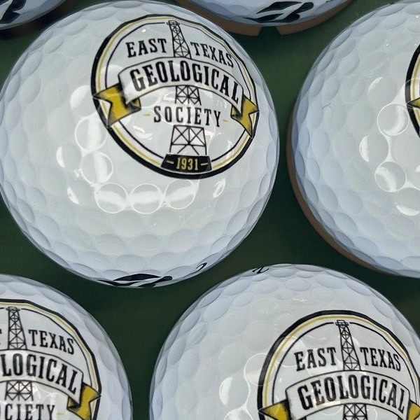 White logo golf balls printed with a black and gold society seal