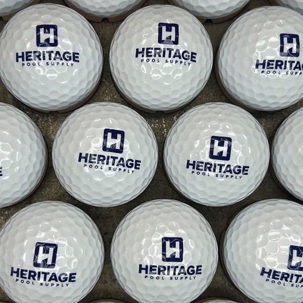 White branded golf balls printed with a navy pool supply logo