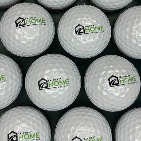 White custom golf balls printed with a black and green house logo
