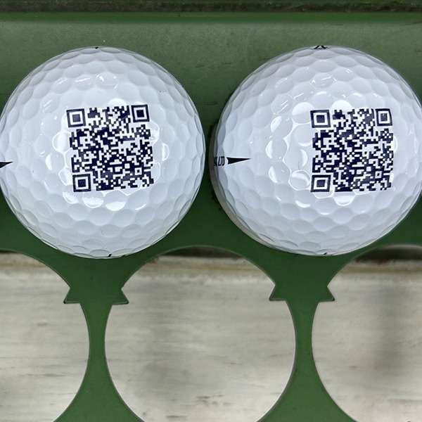White custom golf balls printed with a black QR code