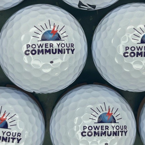 White custom golf balls printed with a community slogan logo