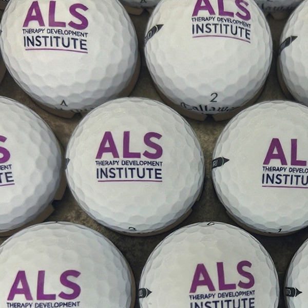 White branded golf balls printed with a purple institute logo