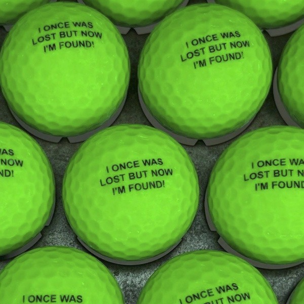 Neon green golf balls printed with a funny lost ball message