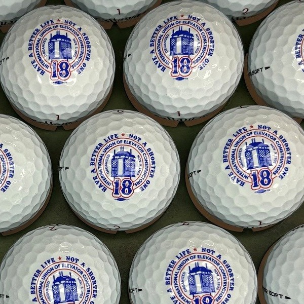 White custom golf balls printed with a blue and red round building logo