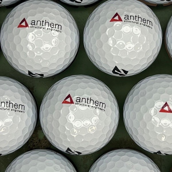 White branded golf balls printed with a red and black company logo