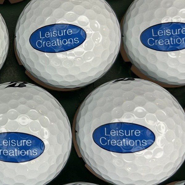 White logo golf balls printed with a blue oval company logo