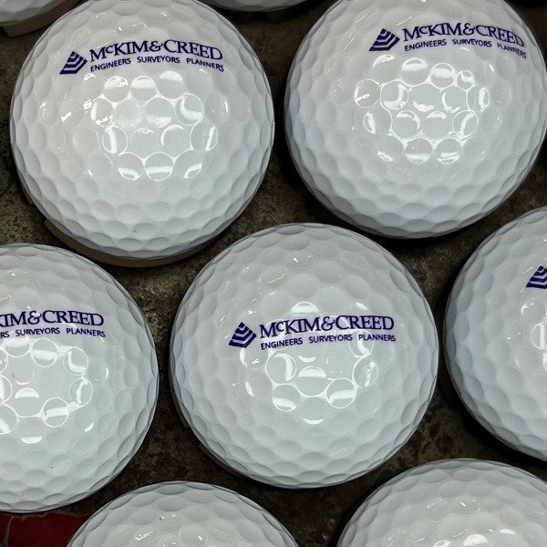 White branded golf balls printed with a purple company logo
