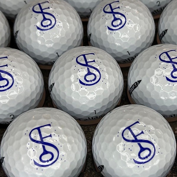 Personalized golf balls featuring a custom blue monogram