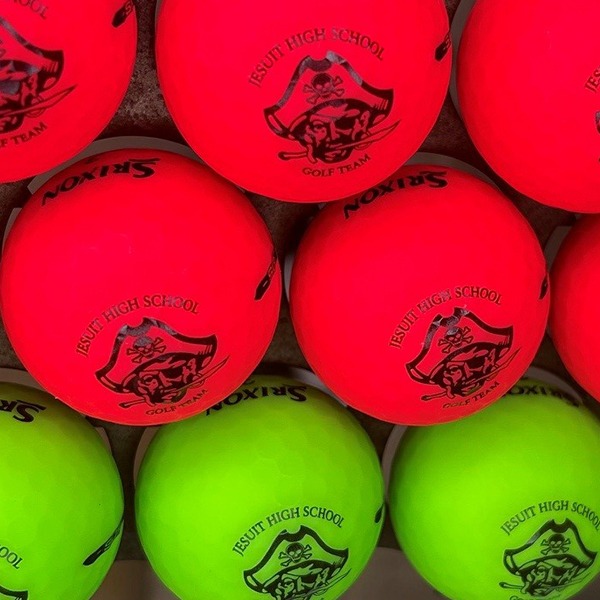Neon red and green custom golf balls printed with a school logo