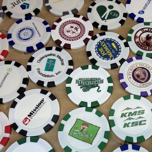 Personalized poker chips featuring assorted colorful organization and event logos