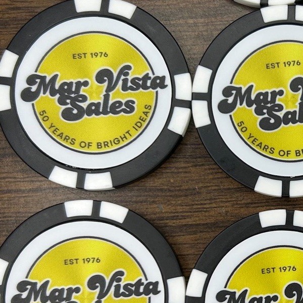 Black and white custom poker chips featuring a yellow anniversary logo design