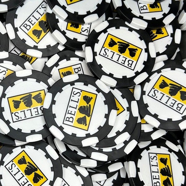 Black personalized poker chips featuring a yellow and black custom logo