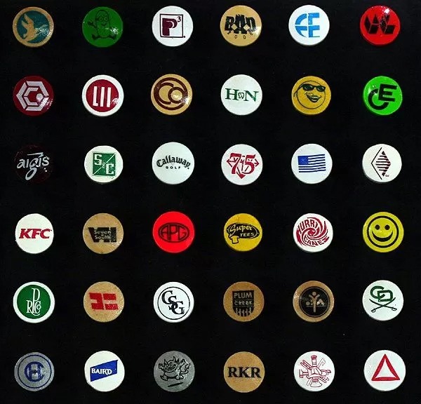 Personalized golf tees featuring assorted logos printed on the tee cups